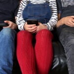Tres niños con diferentes pantallas: tableta, móvil y un mando de videojuegos