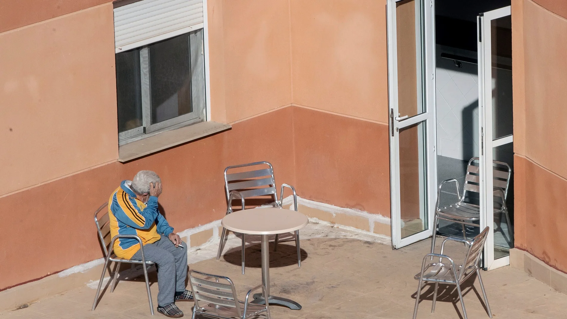 Un hombre toma el sol en una terraza de la residencia de mayores de Villanueva del Río Segura, (Murcia)