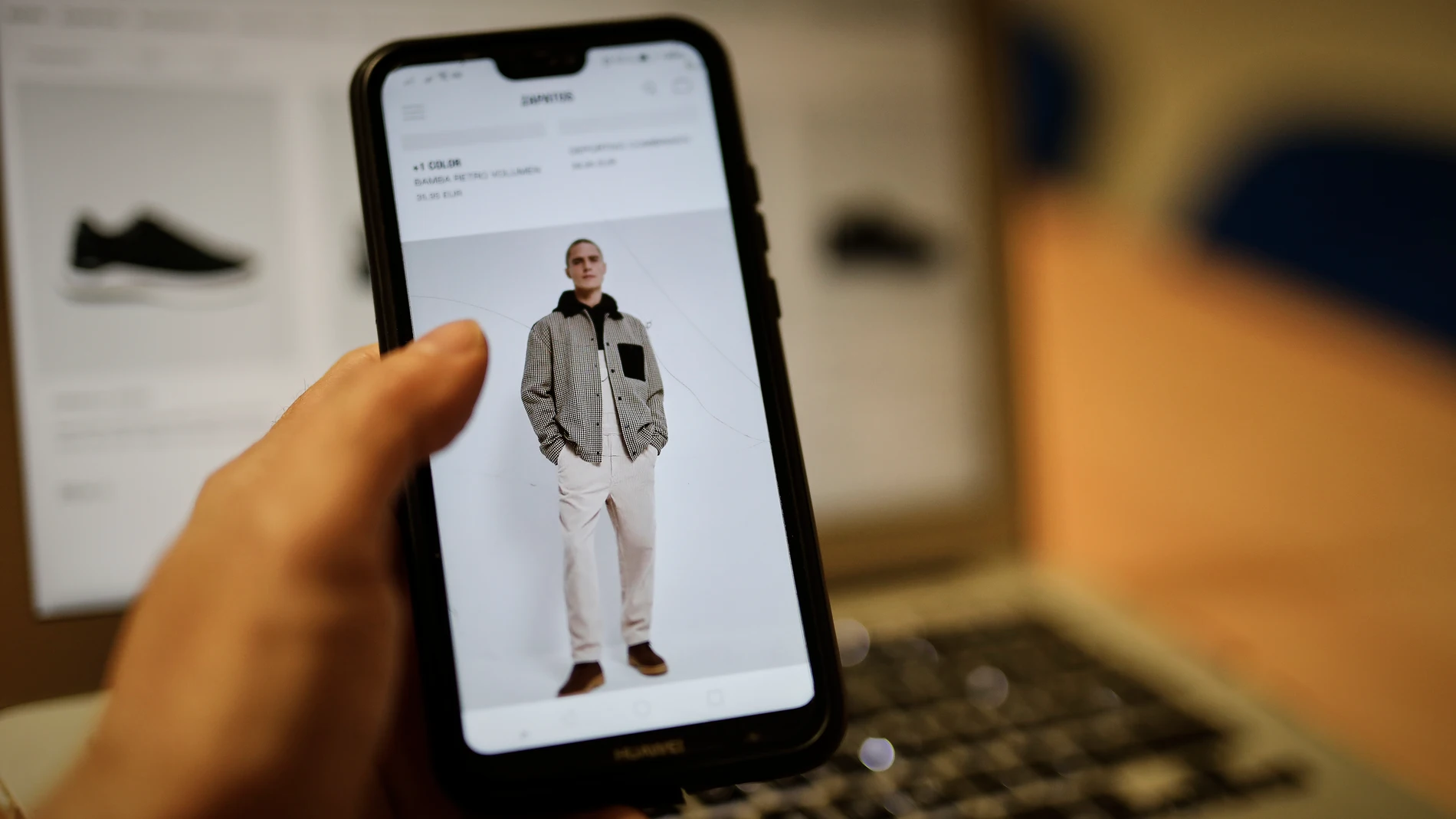 Una persona observa en su móvil artículos de moda en la página de un comercio online