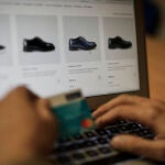 Una persona se dispone a pagar con su tarjeta de crédito una compra online