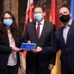 El president de la Generalitat, Ximo Puig, junto a la vicepresidenta Mónica Oltra y el vicepresidente segundo, Ruben Martinez Dalmau, junto a los presupuesto de la Generalitat 2021 aprobados hoy en el pleno del Consell