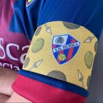 Saetas, balones de cuero y de oro en homenaje a Di Stéfano en el brazalete de capitán del Huesca
