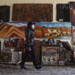 Artist Elizabeth Correa waits for clients to her paints amid the COVID-19 pandemic Cusco, Peru, Monday, Oct. 26, 2020. Cusco, the historic capital of the Inca empire near Machu Picchu lives almost entirely from international tourism and is suffering the worst crisis in its recent history. (AP Photo/Martin Mejia)