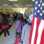 Un grupo de votantes espera su turno para depositar su papeleta en California