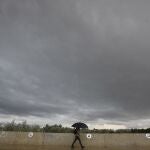 Una persona se resguarda de la lluvia con un paraguas bajo un cielo negro en Córdoba