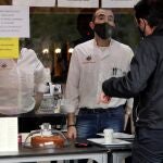 SALAMANCA, 06/11/2020.- Un hombre pide un desayuno para llevar en un establecimiento hostelero este viernes en Salamanca, que despierta con el cierre de la hostelería y los centros comerciales, según lo acordado por el Gobierno autonómico. Podrán abrir los restaurantes y otros alojamientos turísticos, aunque solo para sus clientes o entrega a domicilio o recogida. EFE/J.M.GARCÍA