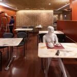 Un trabajador de una cafetería de Murcia limpia el local, cerrado por dos semanas.