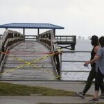 Pedestrians walk past a damaged pier Thursday, Nov. 12, 2020, in Safety Harbor, Fla. Tropical Storm Eta passed just off the coast of Pinellas County with torrential rain and storm surge. Eta dumped torrents of blustery rain on Florida's west coast as it moved over Florida after making landfall north of the heavily populated Tampa Bay area Thursday morning. (Chris Urso/Tampa Bay Times via AP)