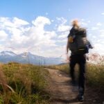 En la imagen, un hombre haciendo senderismo por la montaña.