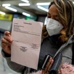 Una pasajera procedente de un vuelo de Colonia (Alemania) muestra el resultado negativo de su PCR