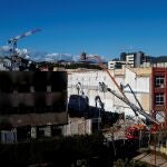 Bomberos de la Generalitat y trabajadores de la empresa de derribos inspeccionan en Badalona el inicio de la demolición de la nave donde murieron tres inmigrantes "sin techo" en un incendio. EFE/ Quique García