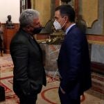 El presidente del Gobierno, Pedro Sánchez, habla con la diputado de Nueva Canarias, Pedro Quevedo (i), en el Congreso