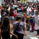 AME5799. SAO PAULO (BRASIL), 18/12/2020.- Una enfermera desinfecta las manos de las personas que caminan en una concurrida vía comercial hoy, en el centro de Sao Paulo (Brasil). El Gobierno brasileño exigirá a partir del 30 de diciembre próximo que los ciudadanos nacionales y extranjeros que desembarquen en cualquier aeropuerto del país procedentes del exterior presenten un examen demostrando que no están contagiados de covid-19. Brasil registró el jueves 1.092 muertes por covid, con lo que volvió a superar el millar de fallecimientos diarios por primera vez desde el 30 de septiembre (1.031) y acumula 184.827 víctimas de la pandemia. EFE/ Sebastiao Moreira