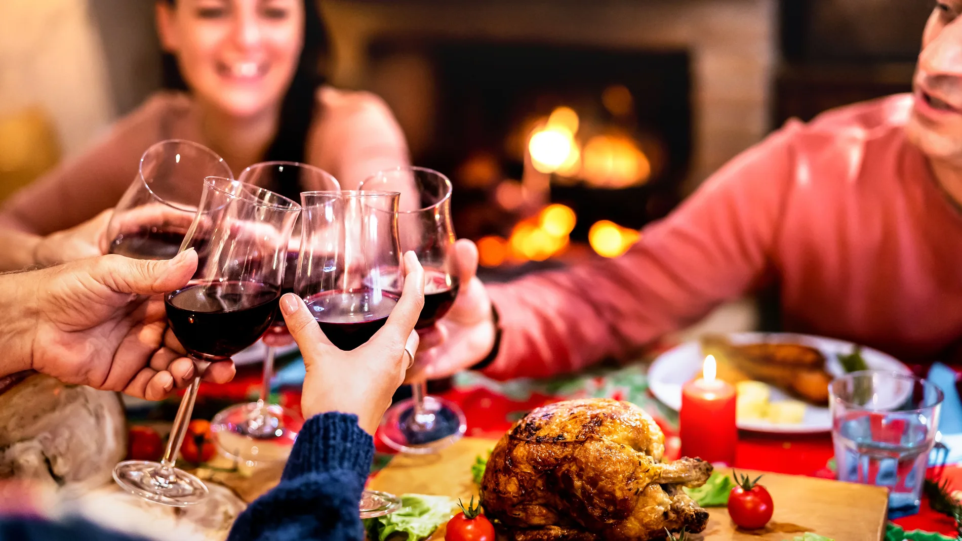 Personas en una cena brindando con vino tinto