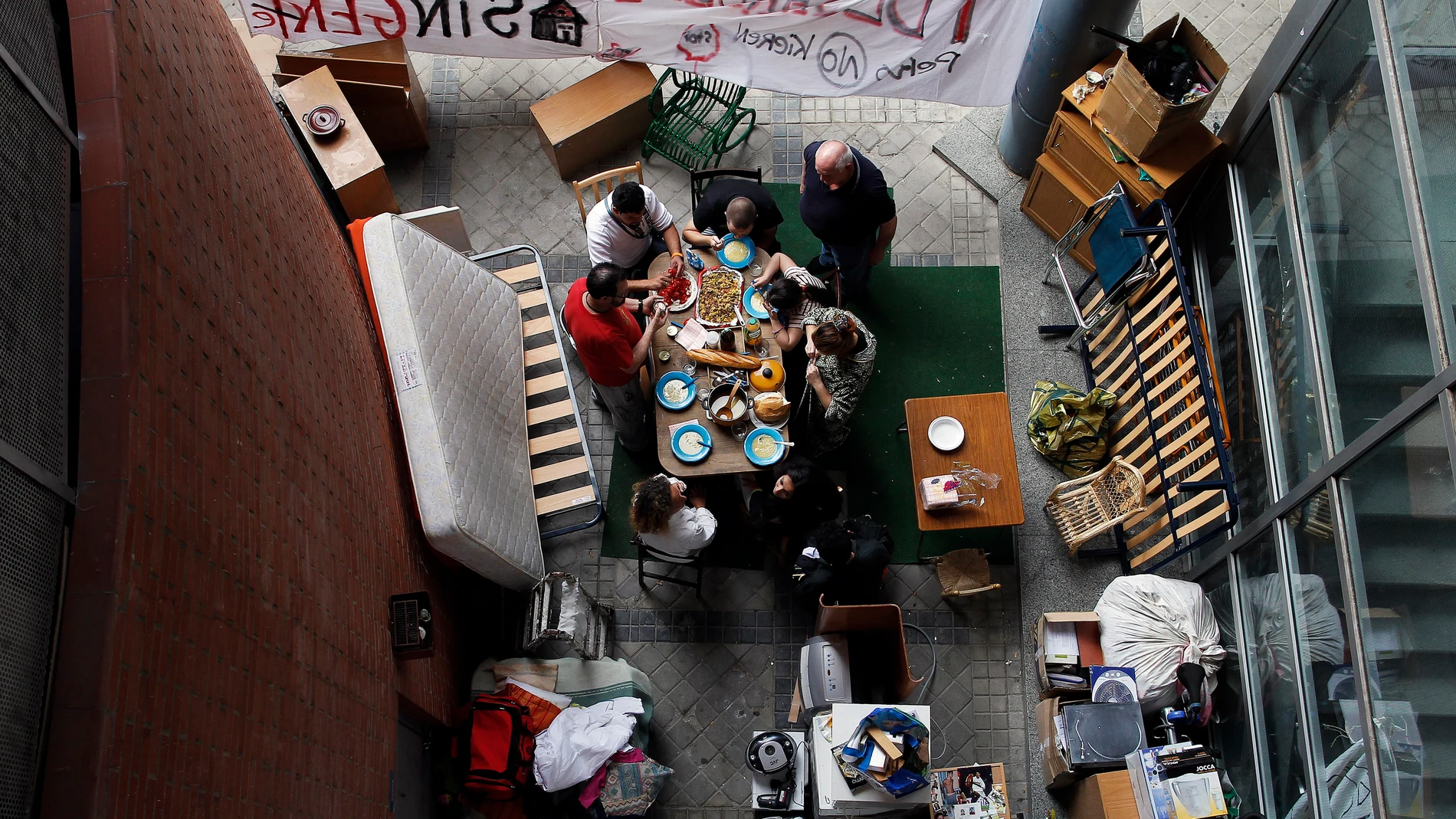Una familia come frente a la puerta de su casa después de ser desahuciada