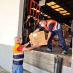 Operarios descargan las cajas con las mascarillas para su reparto