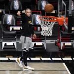 Stephen Curry observa el balón en una sesión de tiro de los Warriors