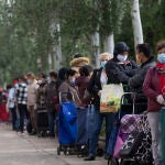 Filas de personas sin recursos económicos hacen cola para que la Asociación de Vecinos de Aluche, sita en la calle Quero, les proporcione productos alimenticios