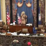 Un hombre con cuernos de bisonte en el sillón de la presidenta del Senado