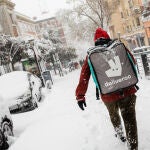 Trabajador de Deliveroo por el centro de Madrid nevado por el temporal causado por la borrasca Filomena.