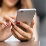 Una joven utiliza un teléfono móvil.