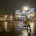 Una mujer pasea a su perro en la Plaza Mayor de Valladolid durante el primer día del toque de queda a las ocho