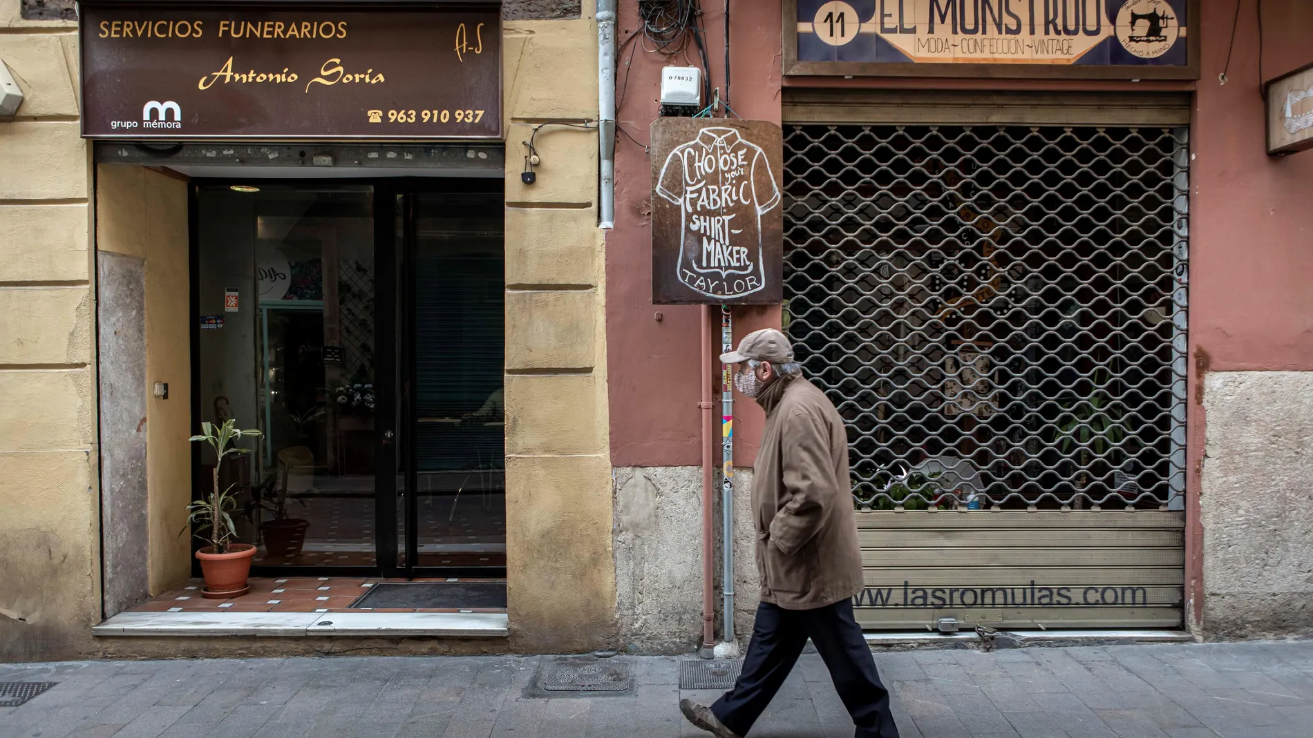 Un pequeño comercio de confección permanece cerrado mientras que una funeraria anexa permanece abierta el pasado mes de enero