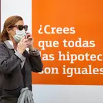 Una mujer pasa por delante de un banco que anuncia hipotecas