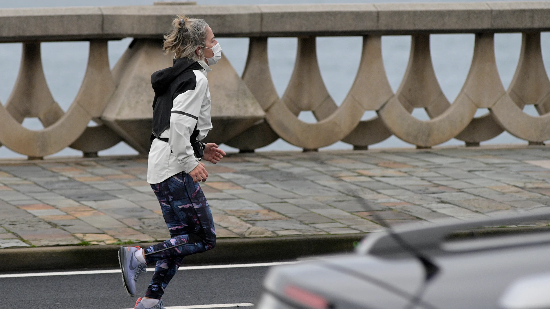 Una persona corre en solitario y con mascarilla un día después de la entrada en vigor de la normativa que obliga a los deportistas a hacer deporte al aire libre con mascarilla y sin compañía en Galicia
