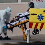 Un sanitario traslada a un enfermo de covid-19