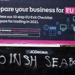 Un hombre pasa junto a un grafiti que dice "Sin frontera con el mar de Irlanda" al sur de Belfast, Irlanda del Norte