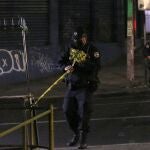 AME2370. SAN SALVADOR (EL SALVADOR), 31/01/2021.- Un policía custodia hoy la escena donde fueron heridos simpatizantes del partido de izquierda Frente Farabundo Martí para la Liberación Nacional en San Salvador (El Salvador). Al menos dos personas murieron y otras cinco resultaron heridas en El Salvador este domingo por la noche víctimas de un ataque armado contra un grupo de simpatizantes del partido opositor Frente Farabundo Martí para la Liberación Nacional (FMLN, izquierda), informó la Fiscalía General de la República (FGR). EFE/Rodrigo Sura