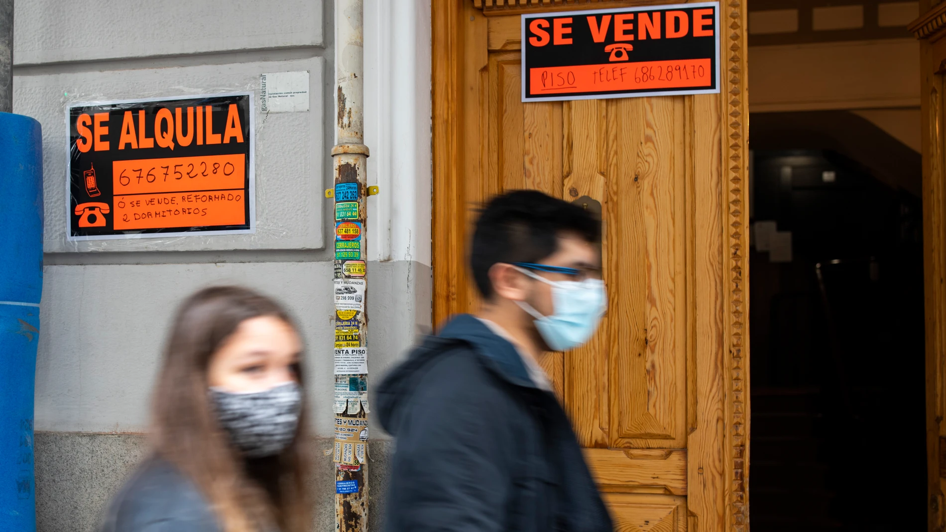 Dos personas pasan por delante de un cartel de "se alquila"