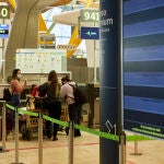 Varias personas facaturan su equipaje en la terminal T4 del Aeropuerto Adolfo Suárez Madrid-Barajas el mismo día en que se restringen los vuelos procedentes de Brasil y Sudáfrica, en Madrid