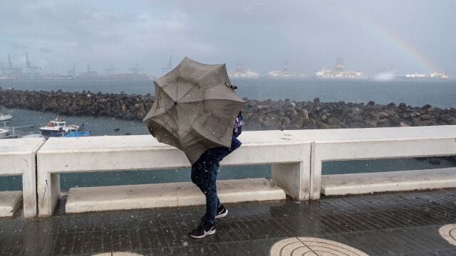  Una persona intenta avanzar ante el fuerte viento y la lluvia