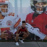 Un joven posa junto al cartel de la Superbowl