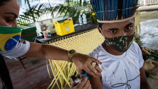 BRA02. AUTAZES (BRASIL), 06/02/21.- Una trabajadora del Distrito Sanitario Especial Indígena (DSEI) de Manaos vacuna a la indígena Ruan Viana, de 18 años, el 5 de febrero de 2021, en el municipio de Autazes, estado de Amazonas (Brasil). En condiciones extremas, la vacunación contra la covid-19 de las comunidades indígenas de la Amazonía brasileña se ha convertido en una odisea a contrarreloj, ante el repentino aumento de contagios y la irrupción de la nueva variante del virus que ya preocupa a medio mundo. EFE/ Raphael Alves
