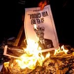 Varias personas participan en la “quema popular” de fotos del rey durante el acto organizado por la ANC en la víspera de la visita de Felipe VI a Barcelona.