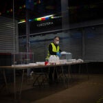 Un operario coloca las urnas, papeletas, gel desinfectante y demás material electoral en una mesa del Mercat del Ninot, de cara a las próximas elecciones catalanas del 14F en Barcelona, Cataluña (España), a 10 de febrero de 2021.10 FEBRERO 2021;ELECCIONES CATALANAS;14F;CATALUNYA;GOVERNMENT;GENERALITAT;URNAS;PAPELETAS;VOTOSDavid Zorrakino / Europa Press10/02/2021