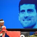 Rafa Nadal, con una imagen de Djokovic de fondo