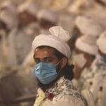 An Indian Muslim groom wearing a mask looks on during a mass marriage where sixty-three couples were married in Mumbai, India, Sunday, Feb. 14, 2021. (AP Photo/Rafiq Maqbool)