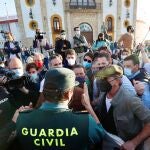 Profesionales y aficionados taurinos hablan con un agente de la Guardia Civil durante la concentración que han realizado en Espartinas