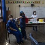 A teacher gets a shot of the CoronaVac vaccine for COVID-19, by China's Sinovac Biotech, at Salvador Sanfuentes public school during the start of the vaccinations for educators in Santiago, Chile, Monday, Feb. 15, 2021. The government aims to vaccinate teachers and school administrative workers nationwide before the start of the school year on March 1. (AP Photo/Esteban Felix)