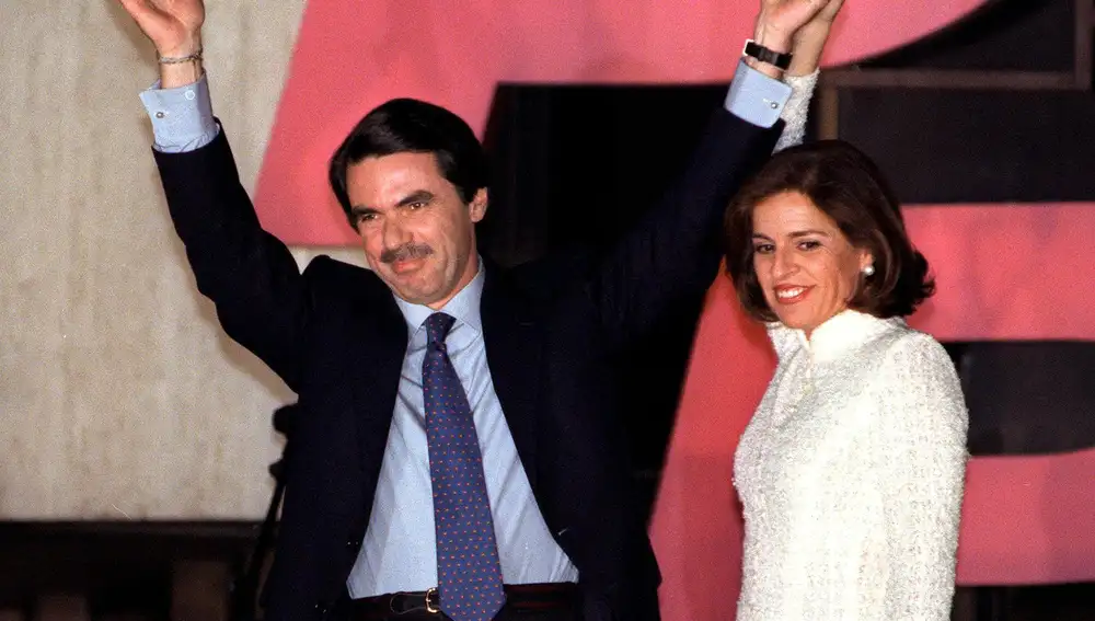 El presidente del Gobierno, José María Aznar, y su esposa, Ana Botella, saludando anoche desde el balcón de la sede del Partido Popular en Madrid a los simpatizantes y afiliados que celebraban el triunfo que el PP ha conseguido en las elecciones legislativas celebradas