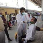 A health worker takes a swab sample of a commuter to test for COVID-19 at a train station in Mumbai, India, Thursday, Feb. 11, 2021. When the coronavirus pandemic took hold in India, there were fears it would sink the fragile health system of the worldâ€™s second-most populous country. Infections climbed dramatically for months and at one point India looked like it might overtake the United States as the country with the highest case toll. But infections began to plummet in September, and experts arenâ€™t sure why. (AP Photo/Rajanish Kakade)