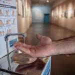 Una persona se aplica gel hidroalcohólico en una de las salas de exposiciones del Museo Valenciano de la Ilustración y la Modernidad (MuVIM).