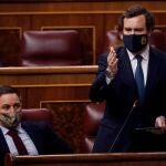 El portavoz de VOX en el Congreso, Iván Espinosa de los Monteros (d), interviene en presencia del líder de su partido, Santiago Abascal