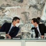 El presidente del Gobierno, Pedro Sánchez conversa con el vicepresidente segundo, Pablo Iglesias durante la reunión del Consejo de Ministros celebrada este martes en Moncloa