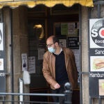 Un hombre sale de un bar que solo ofrece comidas y bebidas para llevar en el municipio de Guitiriz, Galicia (España)