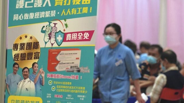 People wait to receive China's Sinovac COVID-19 coronavirus vaccine at a community vaccination centre in Hong Kong, Friday, Feb. 26, 2021. Hong Kong began administering its first COVID-19 vaccines to the public Friday, kicking off its program offering free vaccinations to all 7.5 million residents. (AP Photo/Kin Cheung)